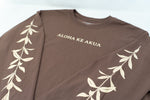 A coco long-sleeve t-shirt with 'ALOHA KE AKUA' printed in beige across the chest and beige maile running down both sleeves
